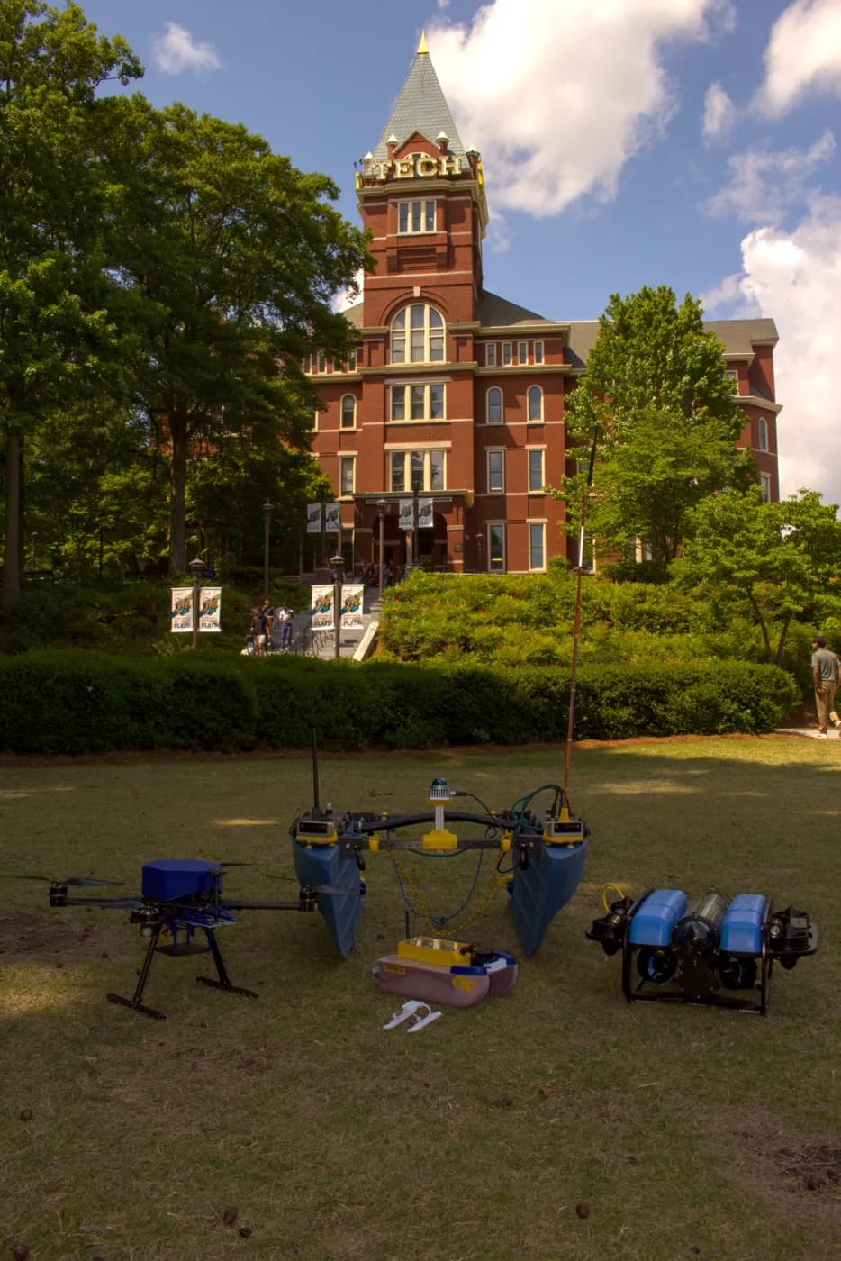 The MRG fleet, a drone, two surface vessels, and an underwater vehicle, lined up on the lawn below Tech Tower